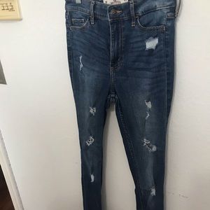 A pair of blue Hollister high rise skinny ripped jeans